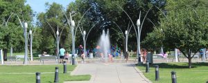 A park in riverside with children playing in a splash zone