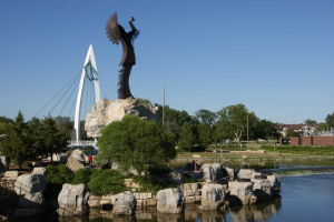 A picture of the arkansas river going by the keeper of the plains, a staple icon in Wichita kansas
